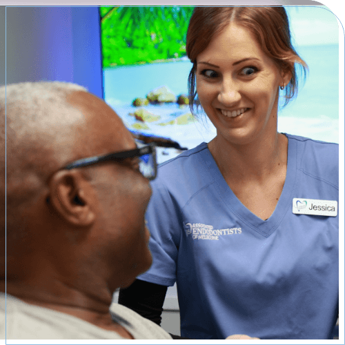 Dental team member smiling while talking to a patient