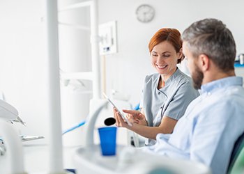 Dental assistant going over insurance with a patient