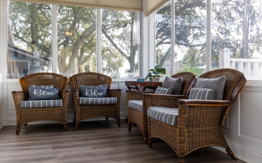 Four wicker armchairs with pillows in waiting area