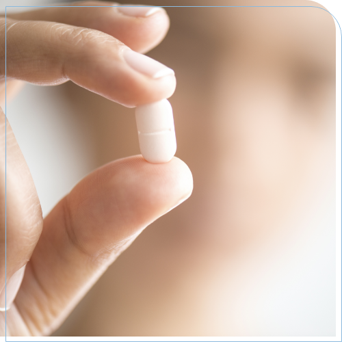 Hand holding a white pill