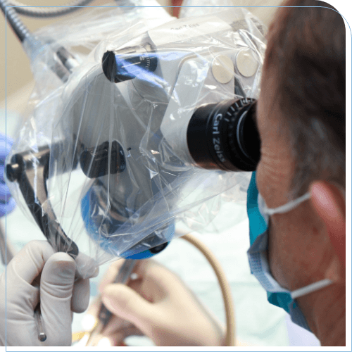 Doctor Scott looking into a microscope while performing root canal treatment