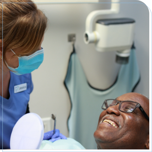 Man in dental chair smiling at dental team member
