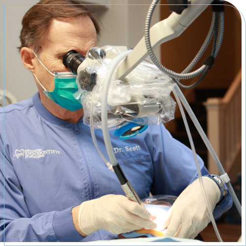 Doctor Scott wearing dental binoculars while performing root canal treatment