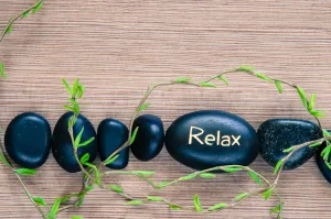 A row of small black rocks with one of them saying Relax